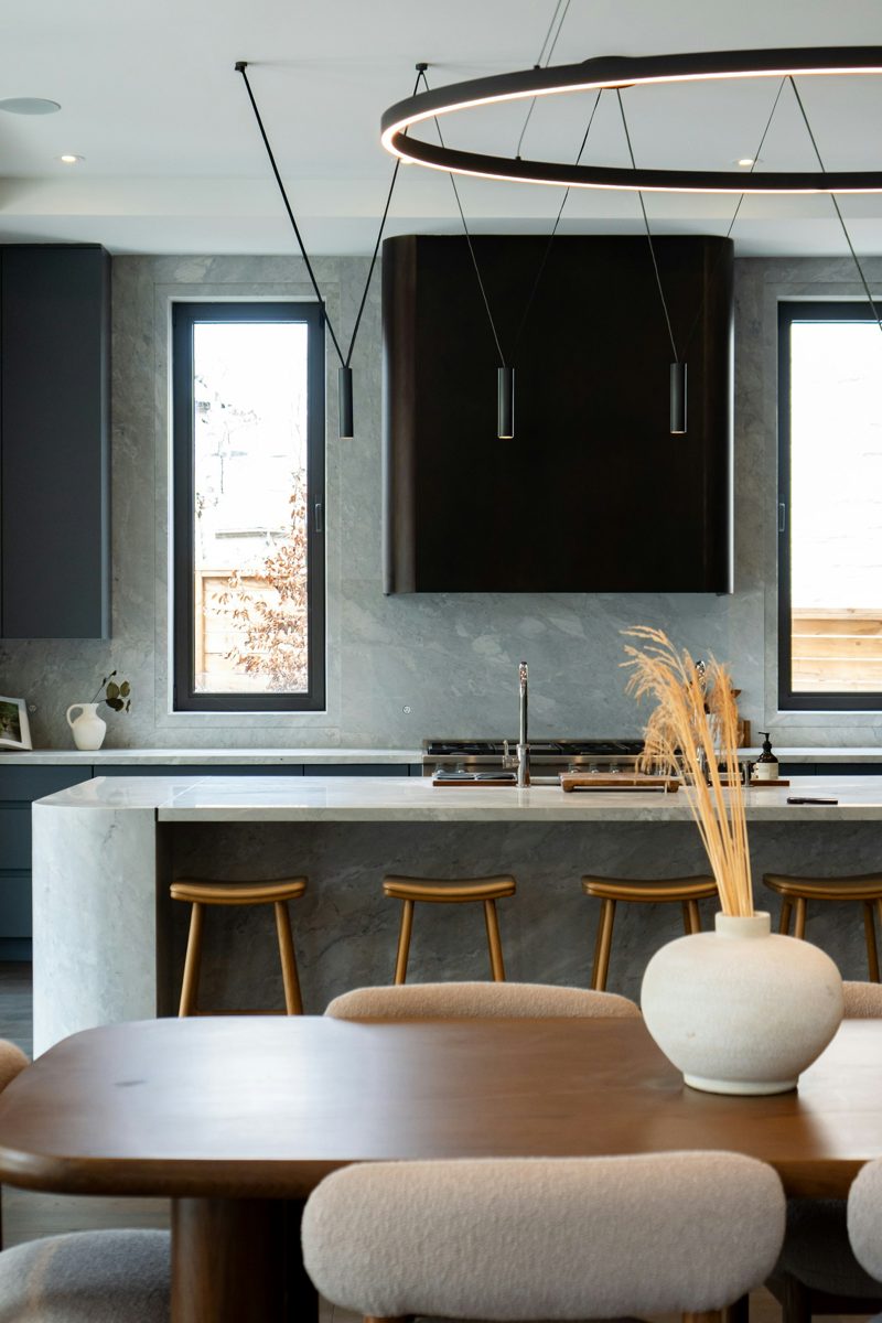Cocina de madera con iluminación natural y barra de desayuno